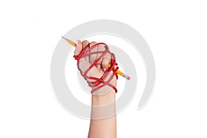 Woman hand with yellow pencil tied with red rope, depicting the idea of freedom of the press or freedom of expression on dark