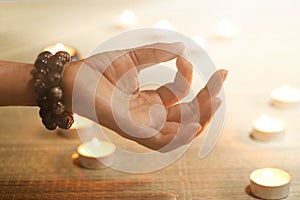 Woman hand yoga and meditation on candle warm glowing background