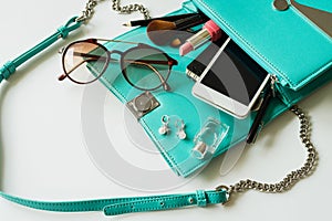 Woman handbag with makeup, cellphone and accessories