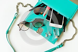 Woman handbag with makeup, cellphone and accessories