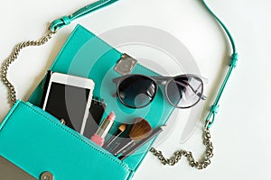 Woman handbag with makeup, cellphone and accessories