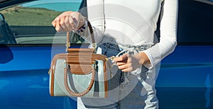 Woman with handbag near the car