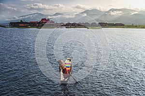 A woman with handcrafted colorful lotus fabrics on her boat in In Dain Khone village, on Inle Lake, Myanmar.