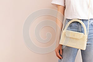 Woman with a handicraft bag made from pearl imitation beads.