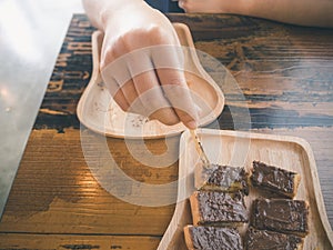 A woman handle stick into the chocolate on topping toast