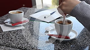 Woman hands adding sugar into coffee in cafe