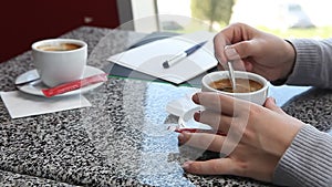 Woman hands adding sugar into coffee in cafe