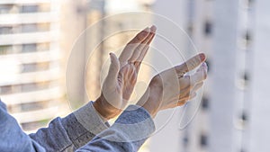 Woman hands applauding medical staff from their balcony. People in Spain clapping gratitude on balconies and windows in photo