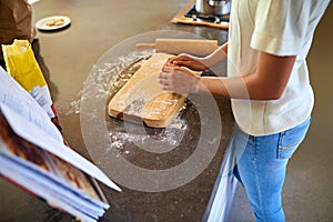 Woman, hands and baking with flour on board in kitchen for new recipe, cookbook or lesson at home. Closeup of female