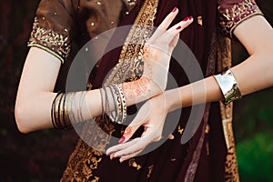 Woman Hands with black mehndi tattoo. Hands of Indian bride girl with black henna tattoos. Fashion.