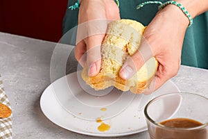 woman hands breaking a sandwich with honey and peanut butter of wheat bread on white plate