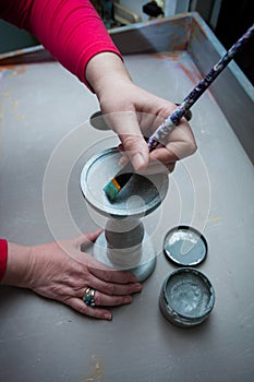 woman hands with brush paint with chalky paint wooden candlestick