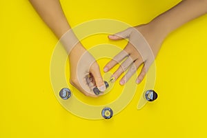 Woman Hands Care. Top View Of Beautiful Smooth Woman`s Hands With Professional Nail Care Tools For Manicure On yellow