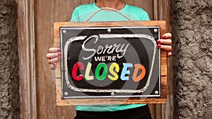 Woman hands with closed sign board on a tropical nature background. Bali island.