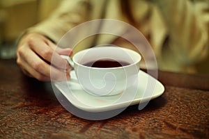 woman hands with coffee cup on a wood table