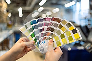 Woman hands with color samples at printing press