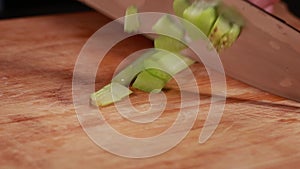 woman hands cutting, chopping celery closeup on wooden board