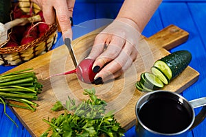 Woman hands cutting fresh crunchy radish on cutting board with c