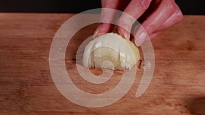 woman hands cutting onion closeup on wooden board