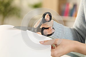 Woman hands cutting paper with scissors at home