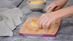 Woman hands cutting pineapple on small pieces.