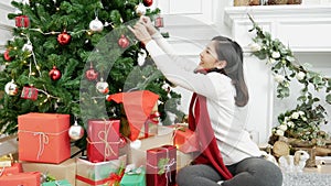 Woman hands decorate Christmas tree red ball, bauble, snow flake. Close up hands holding red ball bauble decorate. Asian woman dec