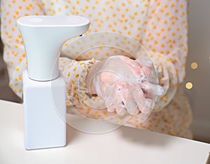 Woman hands disinfect soap automatic dispenser