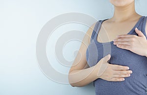 Woman hands doing breast self-exam for checking lumps and signs of breast cancer on white background. Health care and medical