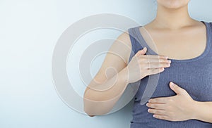 Woman hands doing breast self-exam for checking lumps and signs of breast cancer on white background. Health care and medical