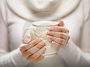 Una mujer manos elegante francés diseno posesión acogedor de punto taza. tiempo de Navidad 