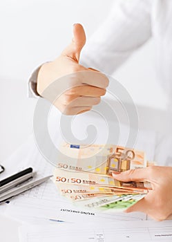 Woman hands with euro cash money and thumbs up