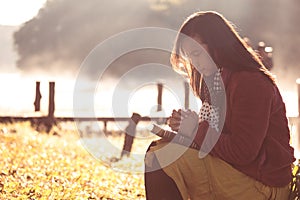 Woman hands folded in prayer on a Holy Bible for faith