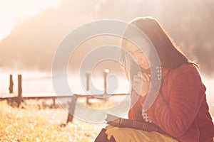 Woman hands folded in prayer on a Holy Bible for faith