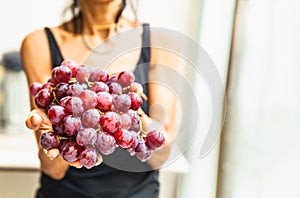 Woman hands with fresh red grapes