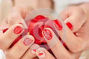 Woman hands full of red petals.