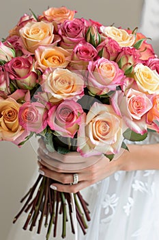 woman hands gently holding a lavish bouquet of roses