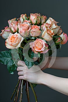 woman hands gently holding a lavish bouquet of roses