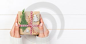 Woman hands give wrapped christmas handmade present in paper with christmas decoration. Present box banner on holiday on dark