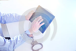 Woman hands in handcuffs with tablet. Hack concept