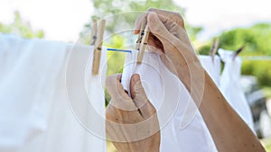 Woman hands hangs laundry on clothesline