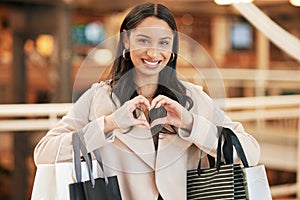 Woman, hands and heart with shopping bags, smile and love for retail boutique with sign. Customer, mall and emoji for