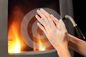 Woman hands heating in front a fire place photo