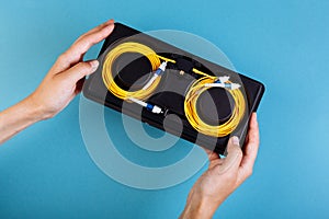 Woman hands hold blue variable optical attenuator on blue background