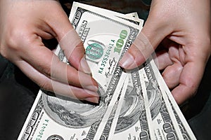 Woman hands hold and counting US dollars banknotes isolated on black background