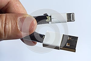 Woman hands hold Damaged white usb cable plug and micro usb plug or Old Smart Phone Charger Cable broken on white acrylic