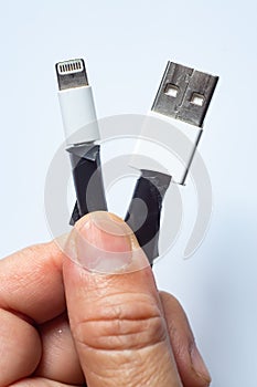 Woman hands hold Damaged white usb cable plug and micro usb plug or Old Smart Phone Charger Cable broken on white acrylic