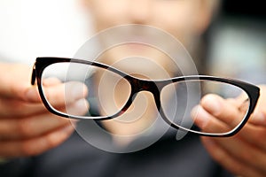 Woman hands hold eyeglasses in front of her