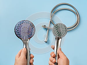 Woman hands hold old and new shower heads. Compare old shower head with limescale and new clean one.