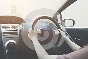 Woman hands holding on black steering wheel while driving a car, Hands of female driver on steering wheel, Auto Concept