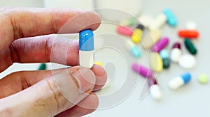 Woman hands holding blue-white capsule of Dicloxacillin, used to treat bacterial infection or treat patient who have pneumonia. photo